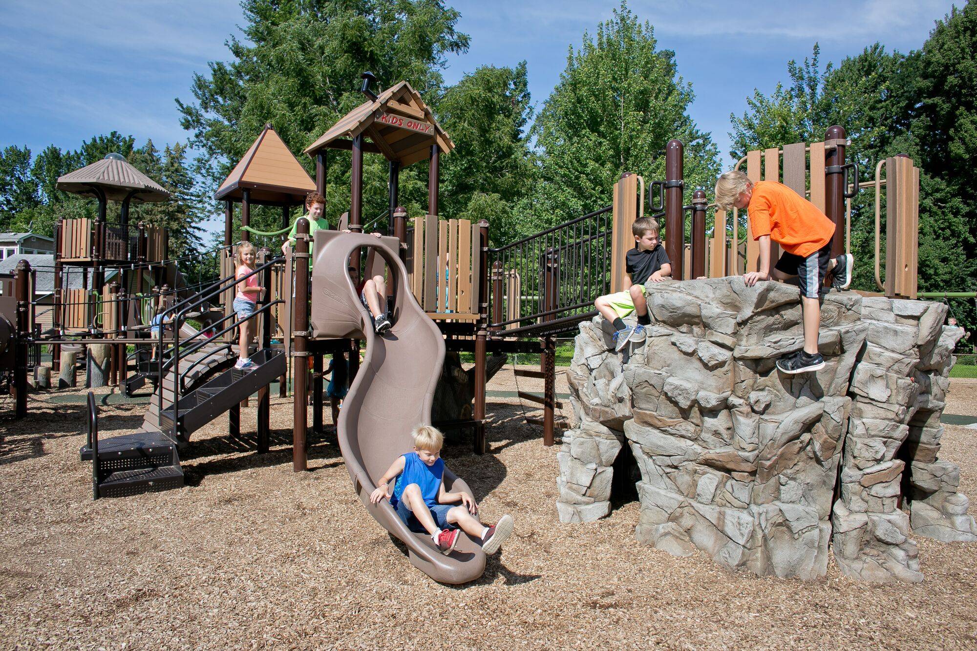 Children playing at a neighborhood playground on a sunny day